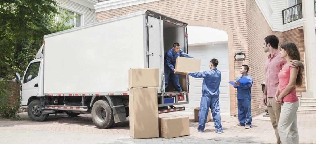 Long-distance movers loading boxes on a truck