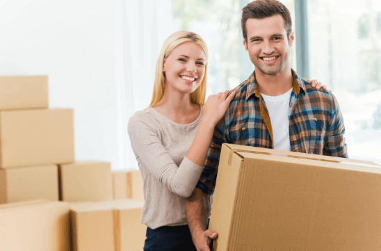 A man and woman packing boxes before cross country moving company comes to load them