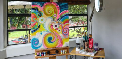 Abstract masterpiece adorns the studio wall, complemented by a picturesque view of the lush garden through the window. A harmonious blend of art and nature in this creative sanctuary.