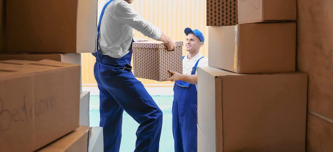 Professional cross-country movers carrying boxes