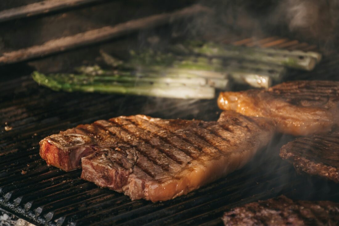 Savoring the perfect meal in Dallas after a move – juicy beef grilling on the barbecue, adorned with green onions. The aroma of the barbecue fills the air, marking a delightful beginning to your new chapter in Dallas, where flavor and warmth come together in a delicious welcome.