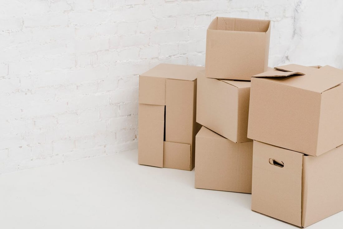 A pile of boxes in front of a white wall