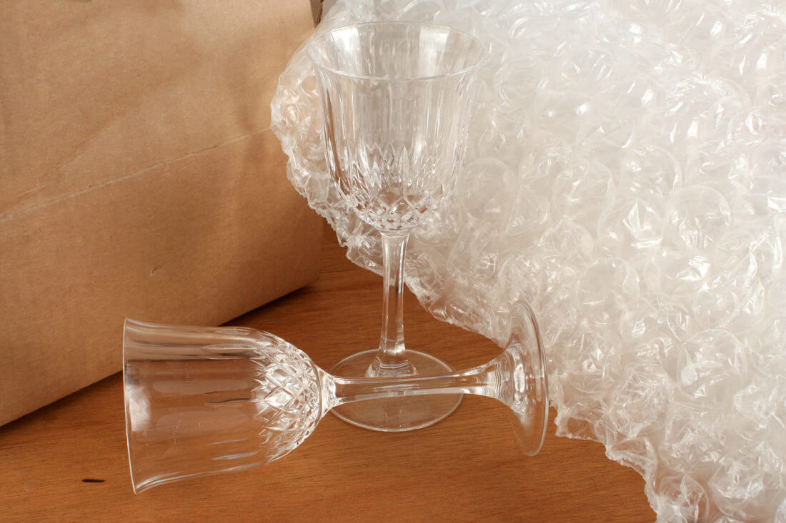 A wine glass next to some bubble wrap