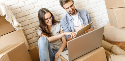 Couple making a to-do list before finding long-distance movers near me