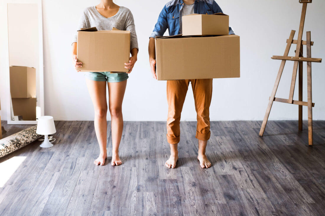 A young couple holding stuff and preparing for cross-country moving