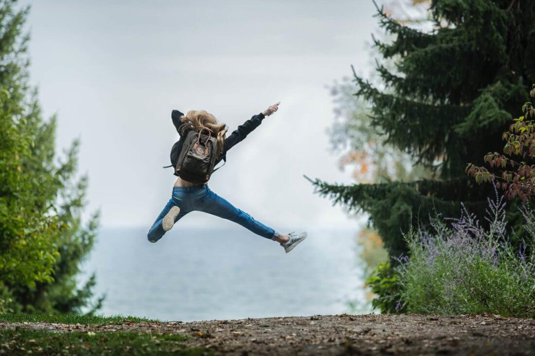 A woman jumping from joy after long-distance moving