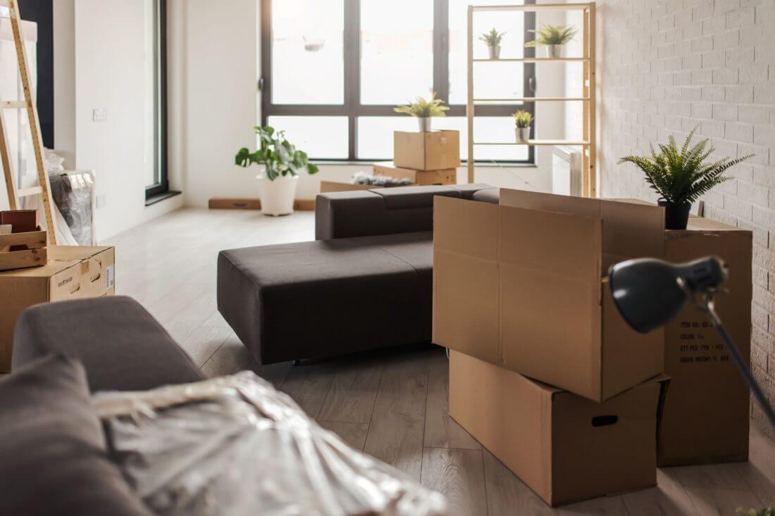 A couch and some boxes sitting in the room after long-distance moving