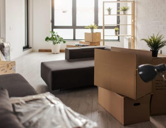a couch and some boxes sitting in the room after long-distance moving