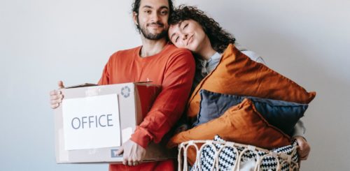 couple is preparing for move, holding boxes and other stuff
