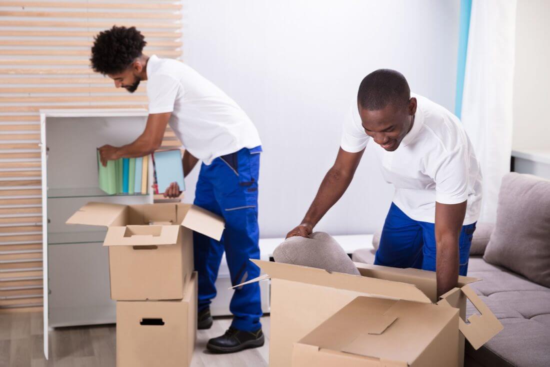 Two long-distance movers packing boxes before long-distance moving