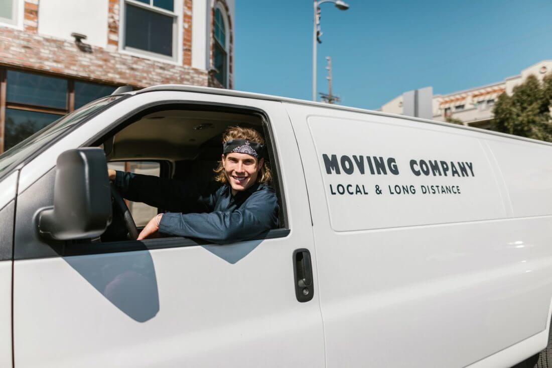 a professional mover driving a white minivan ready for long-distance moving 