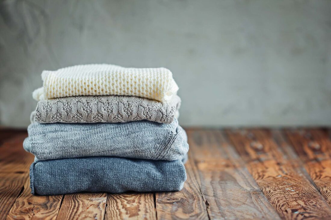 Stack of knitted winter clothes, sweaters