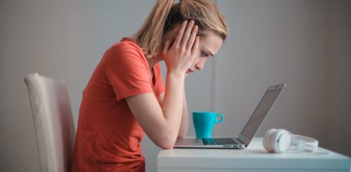 Worried woman in front of the laptop before long-distance moving