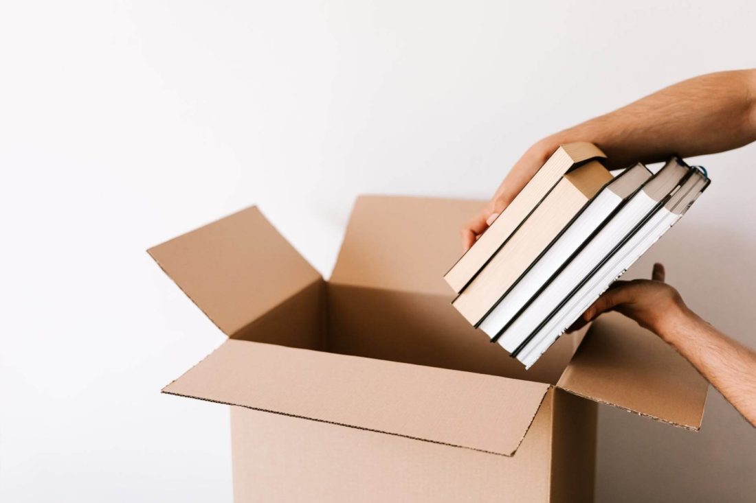 a woman is packing her books for a long-distance moving 