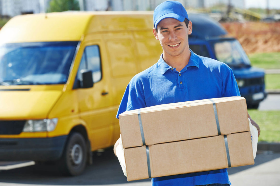 A mover holding boxes and smiling