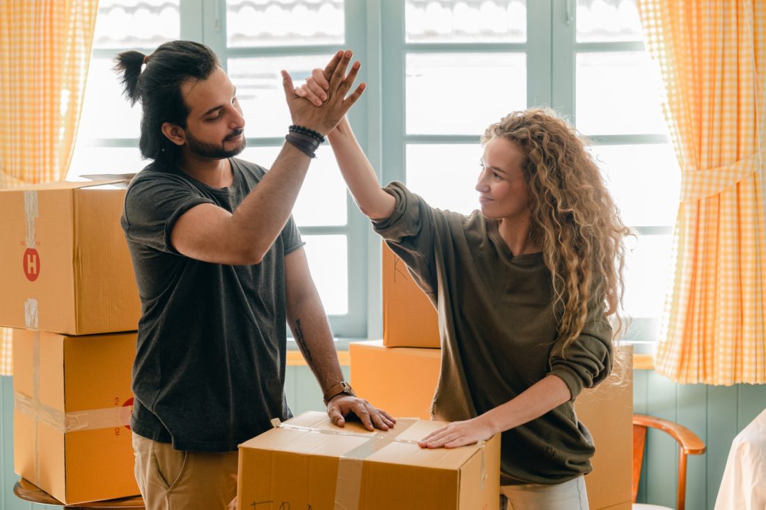 A man and a woman giving high fives after the successful cross-country moving
