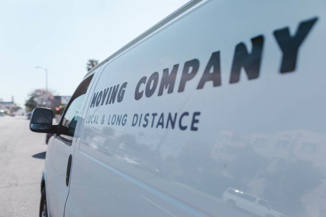 white minivan labeled with local and long-distance moving company logo