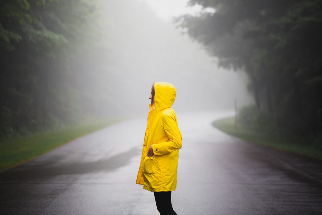 A girl standing outside in a raincoat