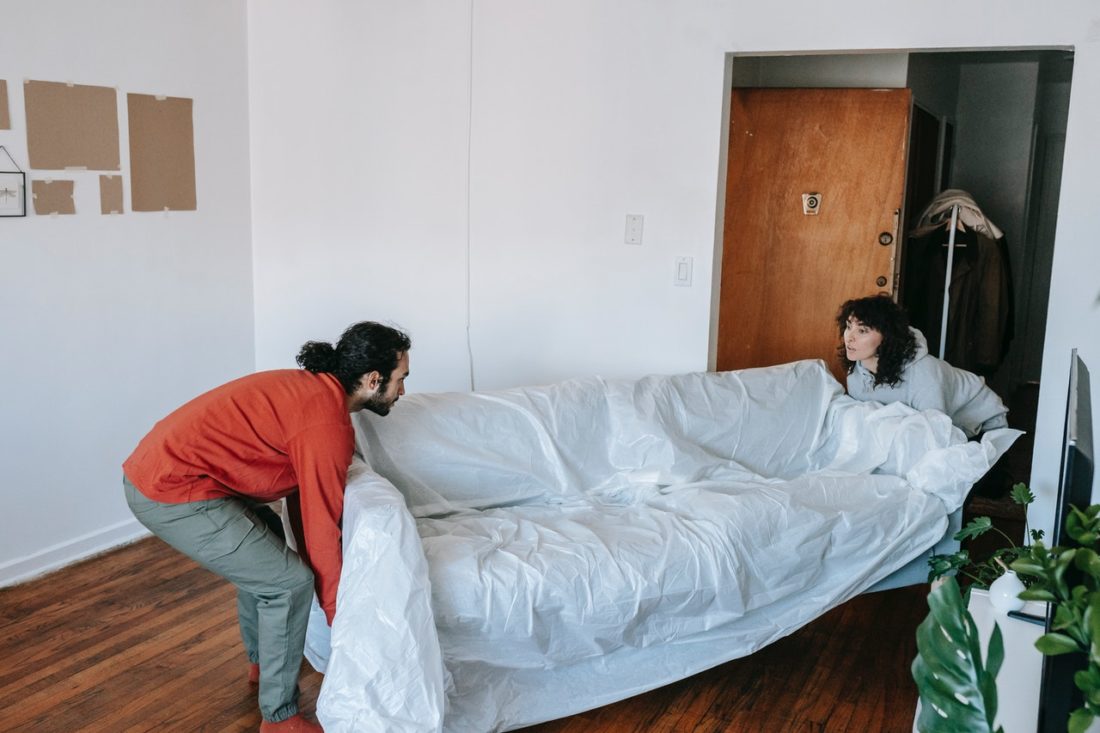 A couple preparing a sofa for long-distance moving