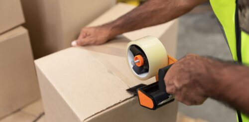 man closing a box with a tape