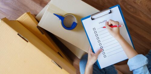 A woman writing a checklist before cross-country moving