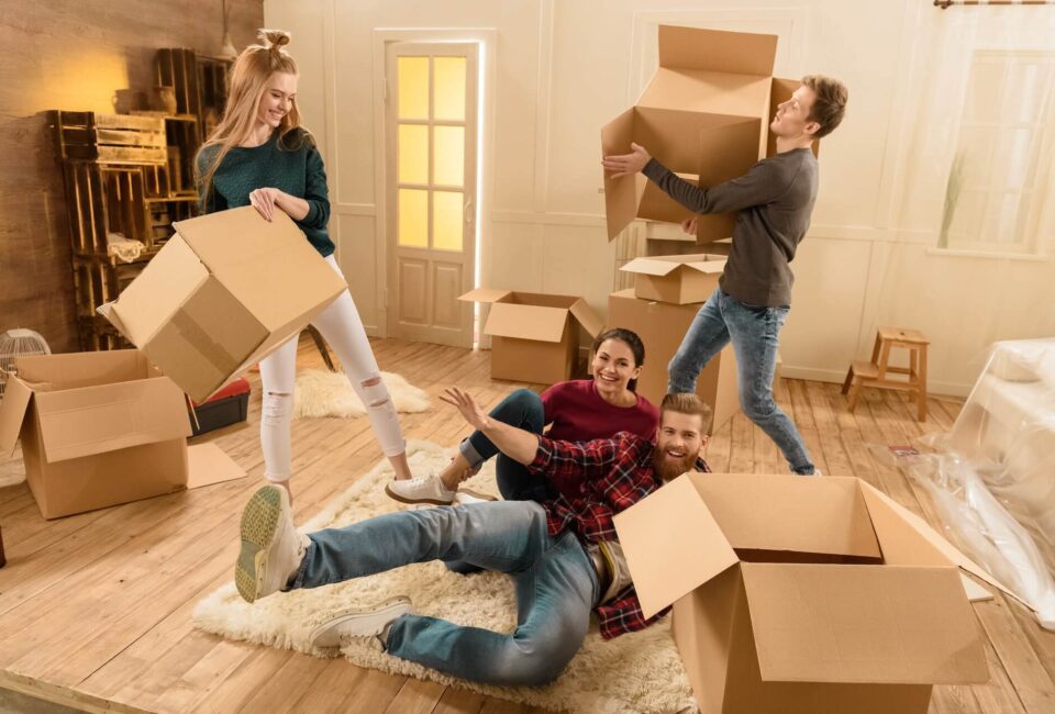 People smiling and carrying boxes