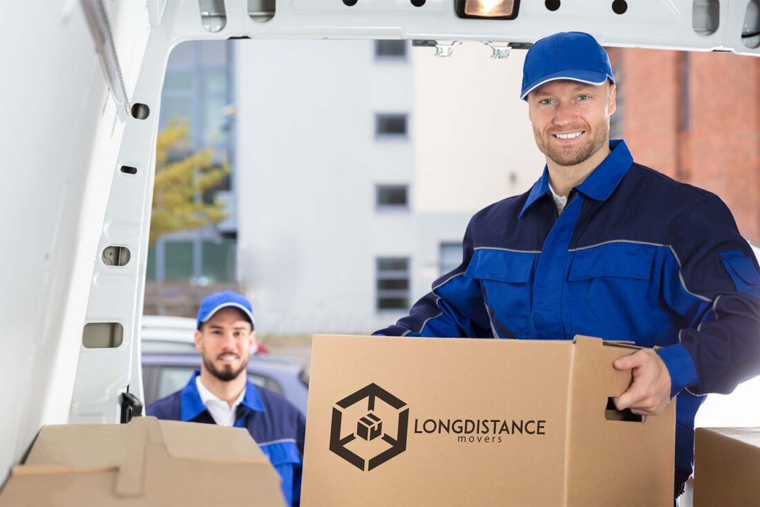 Professional movers carrying boxes inside a new home