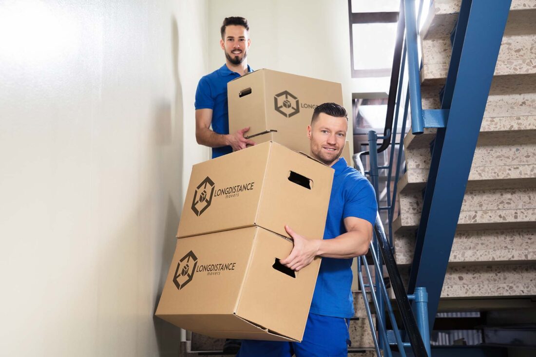Two long-distance movers carrying boxes down some stairs