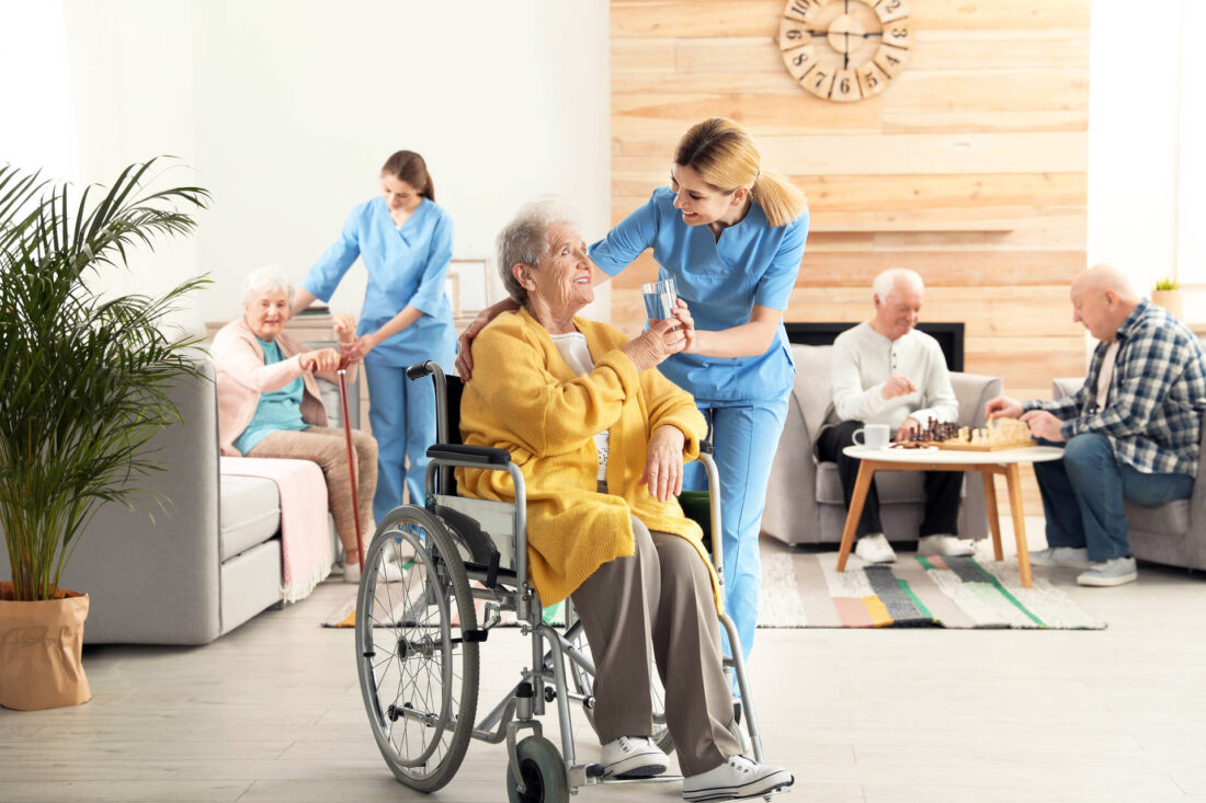 A nurse talking to an elderly woman in a wheelchair