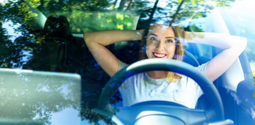 Happy woman sitting in a car
