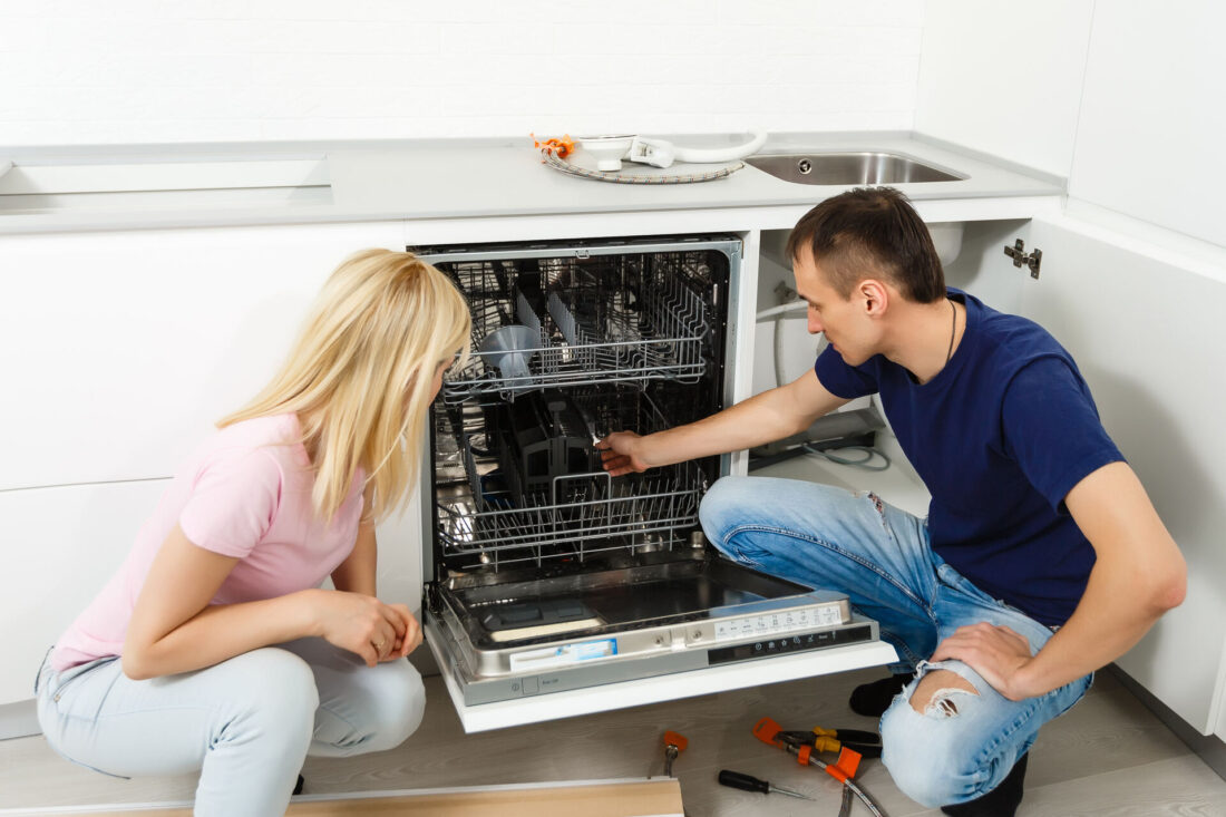 Couple disconnecting a dishwasher