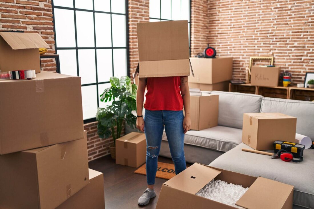 Stressed person with a box on their head, waiting for cross-country movers