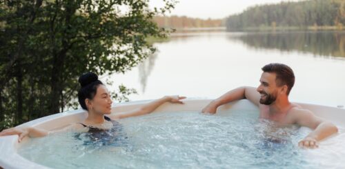 A man and a woman sitting in a hot tub