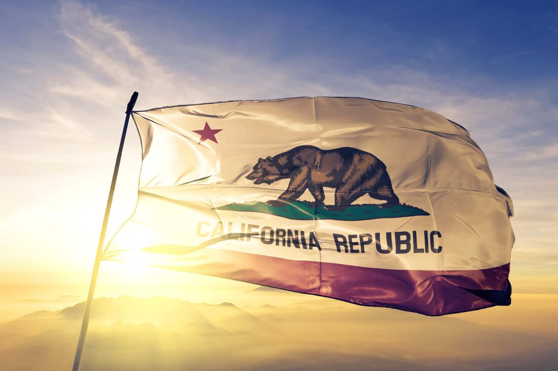 California state of United States flag textile cloth fabric waving on the top sunrise mist fog