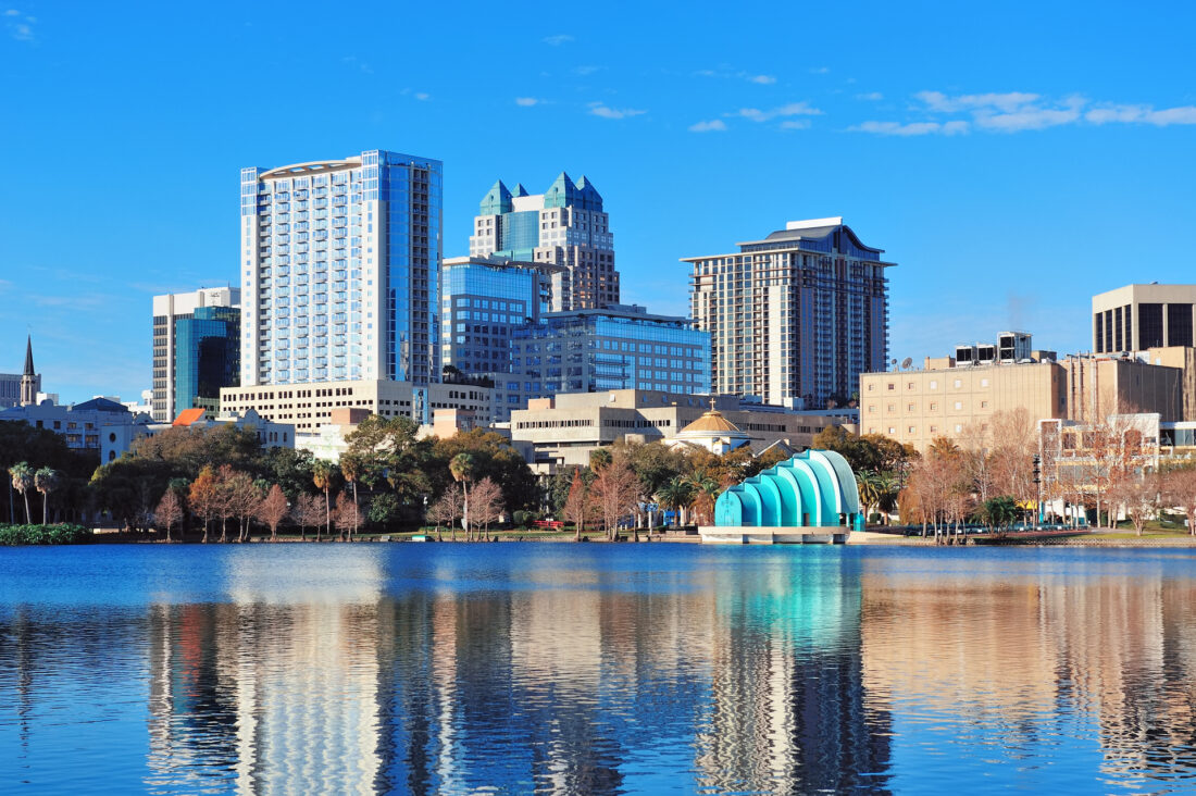 Clear blue skies over Orlando buildings at sunrise.