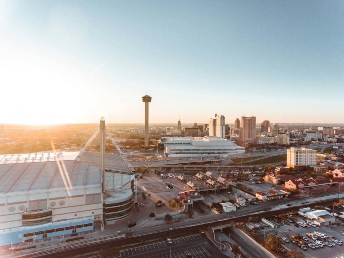 Aerial view of downtown San Antonio, Texas, featuring city buildings and streetscapes under bright daylight.