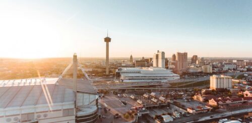 Aerial view of downtown San Antonio, Texas, featuring city buildings and streetscapes under bright daylight.